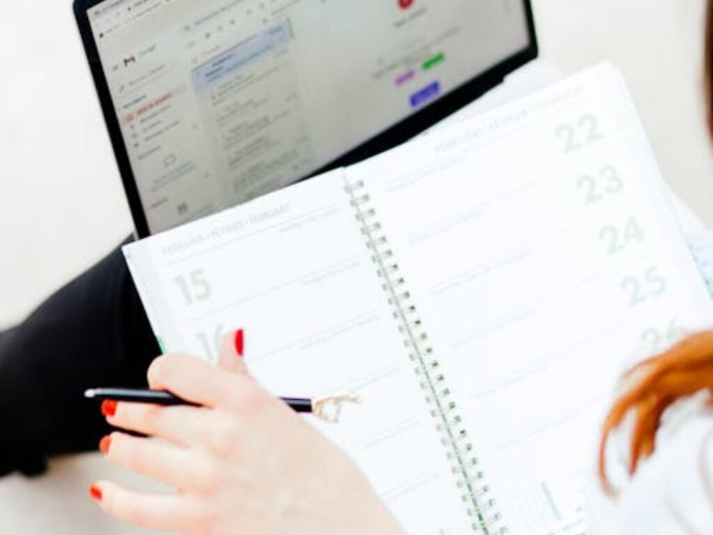 content calendar planning using a notebook and laptop for scheduling social media posts